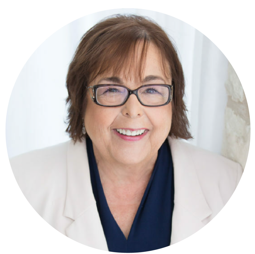 Patti Rossman, a speaker and co-founder. She has chin-length brown hair, rectangular black glasses, and a bright smile.